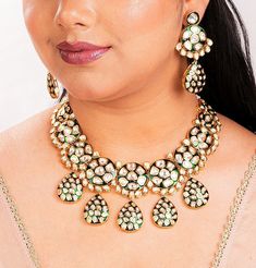 Stunning Kundan and Polki jewelry set inspired by the iconic designs of Sabyasachi Jewelry. This set made with Uncut Polki adorned is an exquisite Green Kundan Necklace featuring intricate Jadau Kundan work. This Pakistani Jewelry is a perfect choice for a bridal ensemble. The set also includes complementary pieces like a Kundan Bridal Set, This is a complete Necklace set with matching earrings and a tikka.  *𝐏𝐑𝐎𝐃𝐔𝐂𝐓 𝐃𝐄𝐓𝐀𝐈𝐋* *    Material:  Brass  *    Plating:  Gold Plated *    Stone:  Semi Precious Kundan & Polki. *DIMENSIONS * Necklace * Weight: 127 gm * Drop Length: 6 Inches * Width: 2.5 Inches Earrings * Weight: 19 gm each * Width: 1.25  inches * Length: 2.8 Inches * Closure : Push Back Tikka *  Weight: 15 gm.  *  Length: 1.3 Inches *  Width: 1.25 Inches *  Top Chain Leng Motif Jewelry For Celebrations, Kundan Necklace With Motifs As Gift, Ceremonial Kundan Jewelry With Motifs, Ceremonial Jewelry With Chandbali Motifs, Temple Jewelry With Motifs For Diwali, Temple Jewelry With Motifs For Festive Occasions, White Motif Jewelry For Diwali, Traditional Green Jewelry With Motifs, Festive Temple Jewelry With Motifs