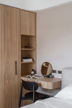 a bedroom with a bed, desk and bookcase in the corner next to it