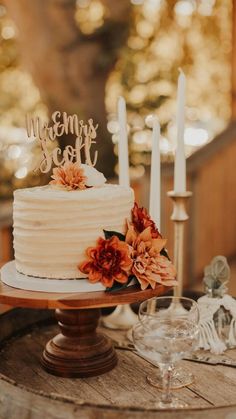 a white wedding cake sitting on top of a wooden table