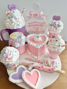 a table topped with cakes and cupcakes on top of a white plate covered in frosting