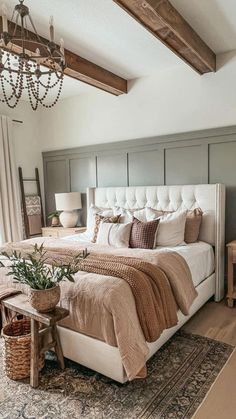 a large bed sitting in a bedroom next to a wooden table with a lamp on top of it