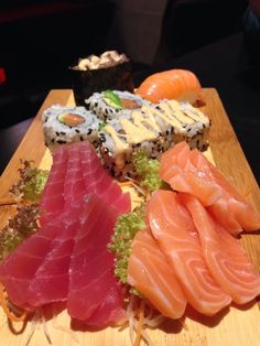 several different types of sushi on a wooden board