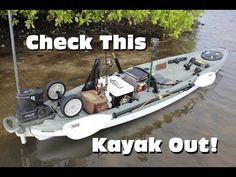 a kayak is sitting in the water with its gear on it's side