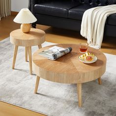 two wooden tables sitting on top of a carpeted floor next to a black couch