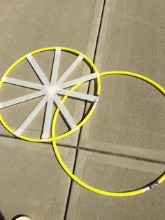 two yellow and white frisbees laying on the ground