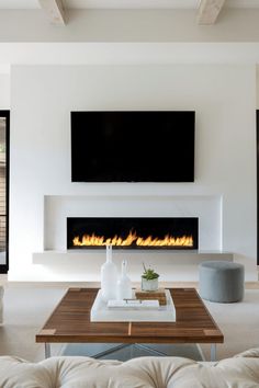 modern living room with fireplace and flat screen tv on the wall, white couches