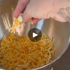 someone is adding cheese to the food in a bowl