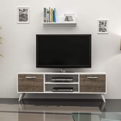 an entertainment center with a flat screen tv mounted on it's side, in front of a white wall