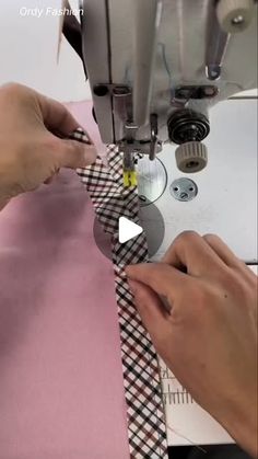 two hands are using sewing machine to sew fabric on pink background with white and black checkered ribbon