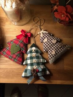 three christmas trees are hanging on a table