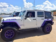 a white jeep with purple accents parked in a parking lot