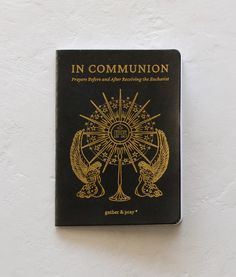 a black and gold book sitting on top of a white wall