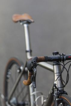 a close up of the handlebars and seat on a bike with grey background