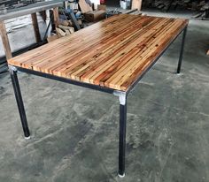 a wooden table with metal legs in a warehouse