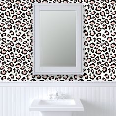 a white sink sitting under a mirror next to a leopard print wallpaper covered wall