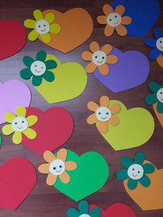 heart shaped cut outs with flowers on them sitting on top of a wooden table in the shape of hearts