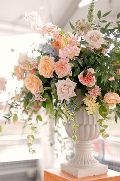 a vase filled with lots of flowers on top of a table