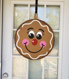 a door hanger with a smiling face on it's front porch window sill