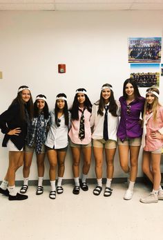 a group of young women standing next to each other in front of a white wall