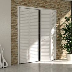 an open white door with shutters in front of a brick wall and potted plant