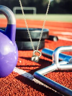 a purple kettle sitting on top of a field next to other exercise equipment and accessories