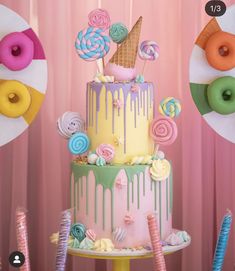 there is a colorful cake with icing and lollipops on the top