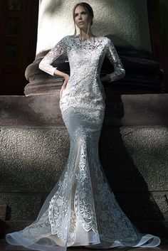 a woman in a white dress standing next to a statue