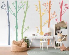 a child's room with colorful trees painted on the wall