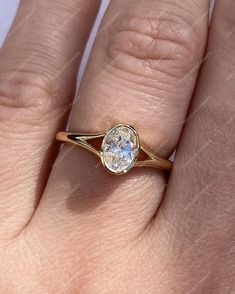 a woman's hand with a gold ring and a white diamond on the side