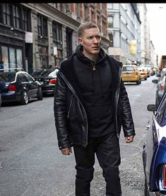 a man standing next to a parked car