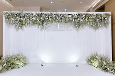 the backdrop is decorated with flowers and greenery