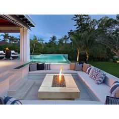 a fire pit sitting on top of a patio next to a swimming pool