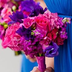 the bridesmaids carried bright bouquets of purple and pink flowers in their dresses