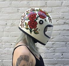 a woman wearing a helmet with flowers painted on it