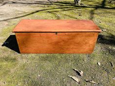 an old wooden box sitting in the grass