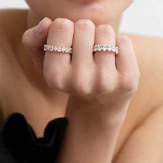 a woman wearing a ring with three stones on it