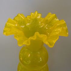 a yellow glass vase sitting on top of a table