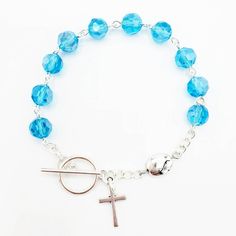 This handmade rosary bracelet is made with 8mm blue topaz Chinese crystal beads and an 10mm Tibetan silver Our Father bead featuring a 1 inch silver-plated cross. All findings are silver plated. All rosary parts are made in Italy. This bracelet is 7.5 inches long. Please choose a Patron Saint Medal to add to your bracelet! (included Each bracelet in my shop is handmade by yours truly. And I back all of my work with a 100% satisfaction guarantee. If you are not completely satisfied, please contac Blue Topaz Crystal, Handmade Rosary, Topaz Crystal, Rosary Bracelet, Our Father, Saints Medals, Patron Saints, Have A Blessed Day, Drawstring Pouch