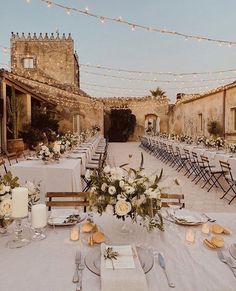 an outdoor dining area with tables and chairs set up for a formal function in the evening