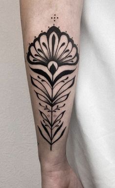 a black and white flower tattoo on the arm