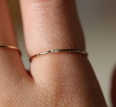 a woman's hand with a gold ring on her finger and diamond in the middle