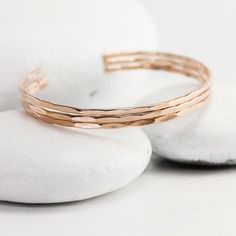 These solid rose gold cuffs have been textured and hammered so that they sparkle and shine. They're made from solid 14K rose gold and they're custom-tailored to you for your comfort. They're meant to be layered as stacking bracelets and they are just about 2mm wide.  I've hammered the length of the cuff by hand and it leaves them full of glitter and sparkle - so glamorous. Additional sizing questions or information can be included in the Notes box at checkout.Shop home: lotusstone.etsy.comMore c Hammered Rose Gold Cuff Bracelet Gift, Elegant Hammered Rose Gold Bracelets, Adjustable Hammered Rose Gold Bangle, Hammered Rose Gold Bangle, Gold Cuff Bracelets, Rose Gold Cuff Bracelet, Gold Cuff Bracelet, Rose Gold Bangle, Stacking Bracelets