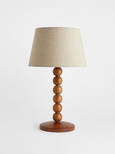 a wooden table lamp with a beige shade