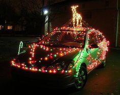 a car decorated with christmas lights in the driveway