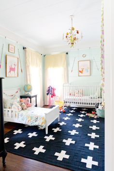 a baby's room with blue walls and white furniture