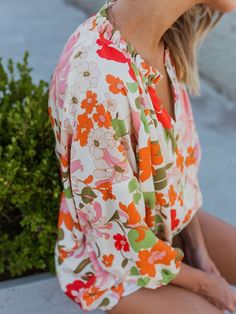 Orange Blooming Flowers Frill Trim Puff Sleeve Blouse Description: Feel charming and attention-getting with this floral blouse. Features a frilled collar with split v cut and 3/4 length puff sleeves. Relaxed fit style for comfort and effortless style. Stylish floral pattern with lightweight 100% Polyester fabric. Suitable for spring, summer, and fall seasons. Available in different sizes to choose from. Perfect for daily wear, vacation, or casual outings. Wholesale this trendy piece for the late Spring Multicolor Puff Sleeve Blouse, Multicolor Puff Sleeve Blouse For Spring, Pink Floral Print Blouse With Split Neck, Pink Floral Print Split Neck Blouse, Feminine Floral Print Top With Split Neck, Pink Split Neck Blouse With Floral Print, Multicolor Balloon Sleeve Blouse For Spring, Spring Floral Print Top With Split Neck, Spring Floral Print Split Neck Top