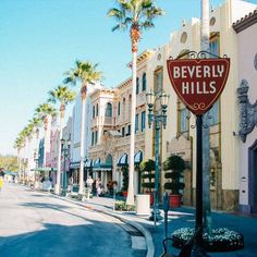 there is a sign that says beverly hills in front of the buildings on this street