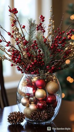 a glass vase filled with ornaments on top of a table