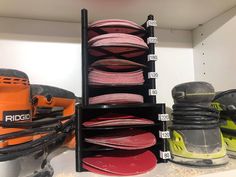 several different types of sanding discs are on display in a storage unit with black shelves