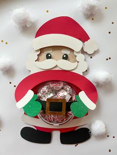 a paper santa clause holding a candy box